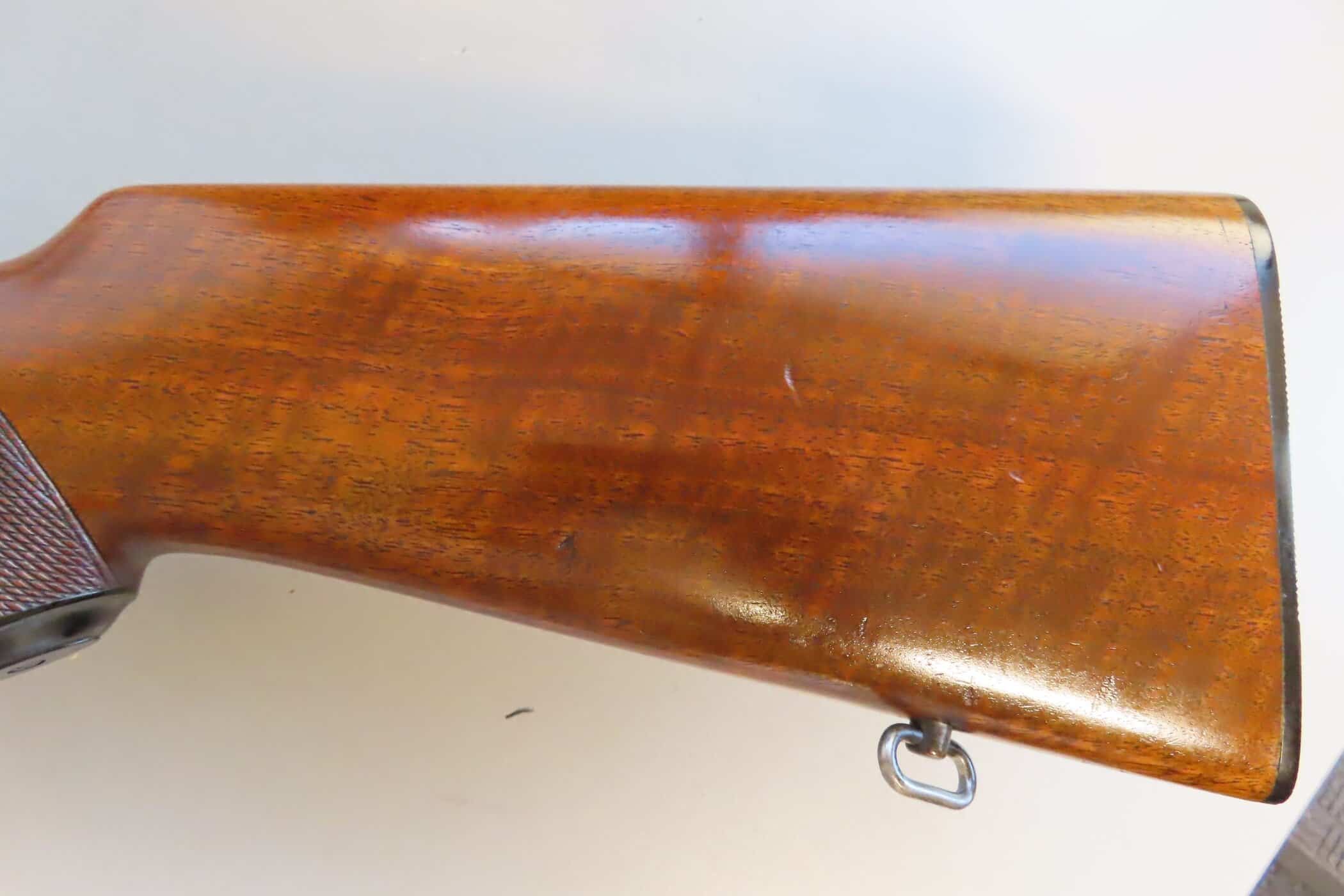 Traditional wooden rifle stock with metal sling swivel for antique firearm collectors.