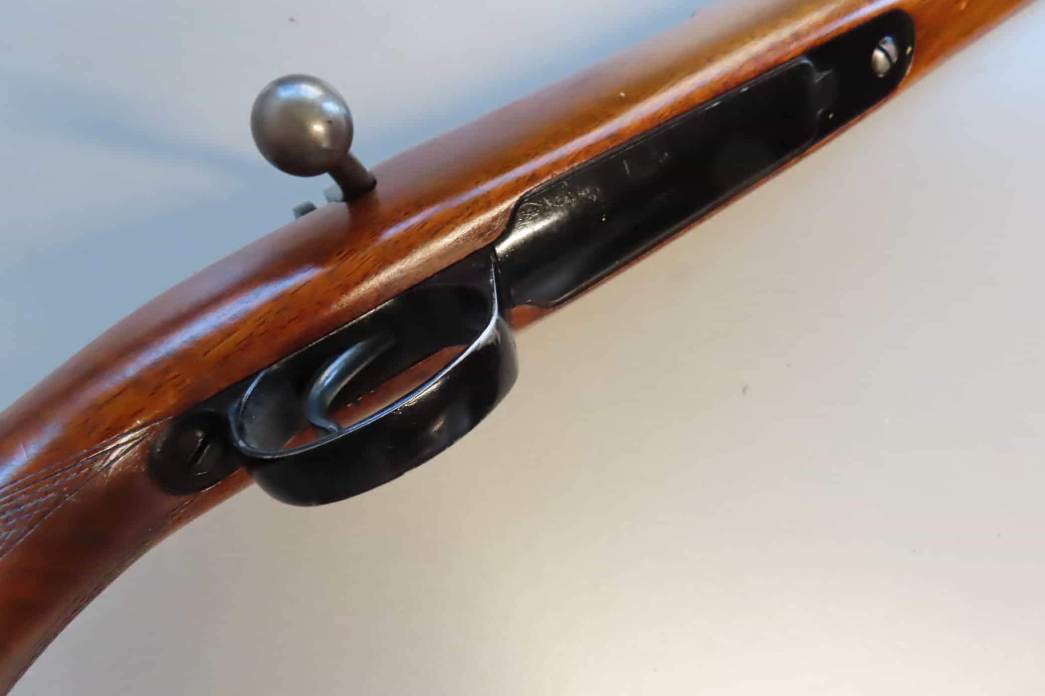 Antique firearm with wooden stock and metal trigger assembly, showcasing historical firearm craftsmanship.