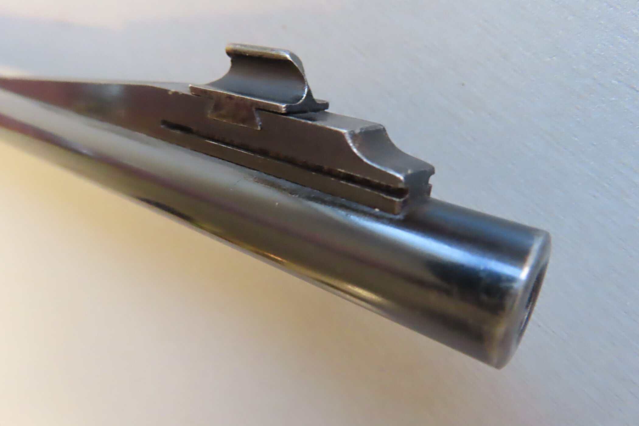 Close-up of a polished firearm barrel with iron sights at Colonial Ammunition Company, NZ.