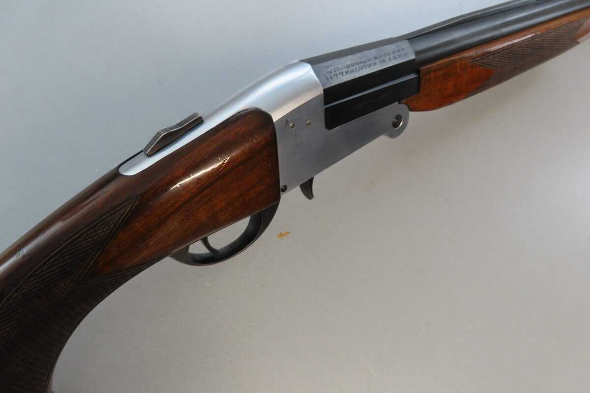 Detailed close-up of a vintage rifle with wooden stock and metal receiver, highlighting firearm collection value.
