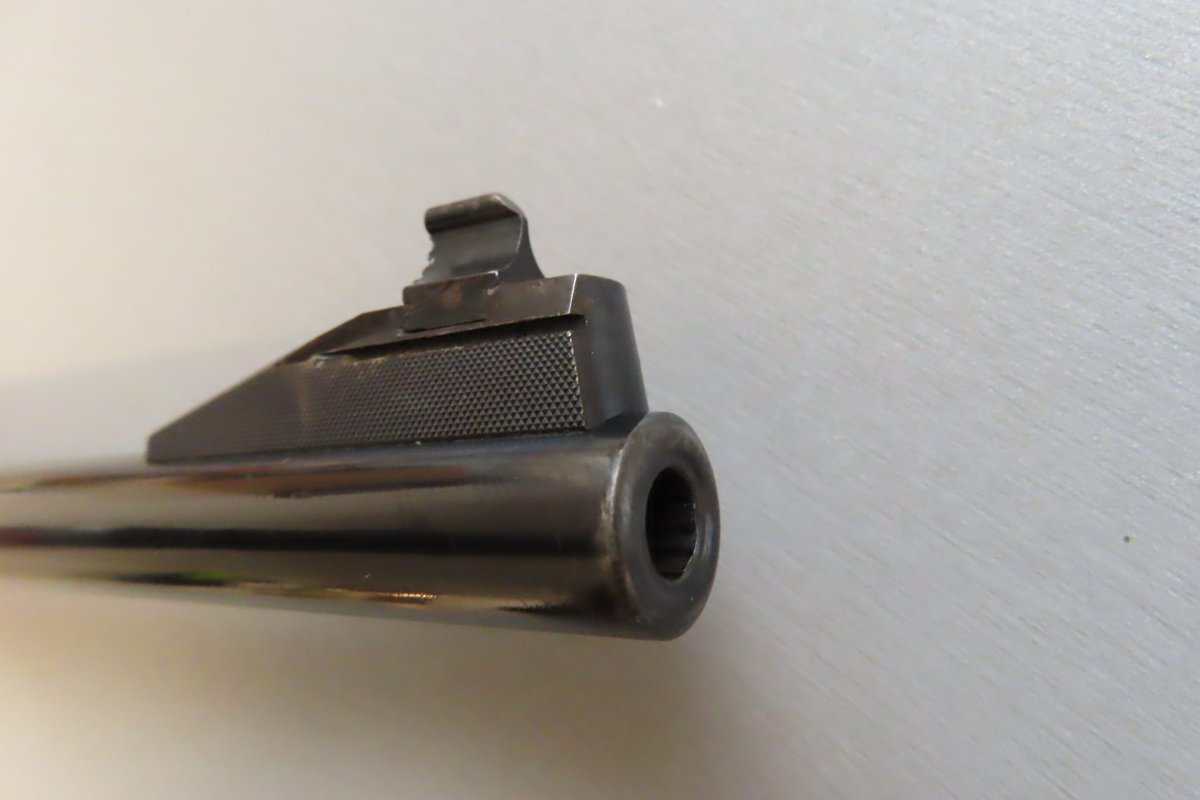 Close-up of a vintage pistol barrel with iron sights, representing high-quality ammunition and firearm accessories from Colonial Ammunition Company.