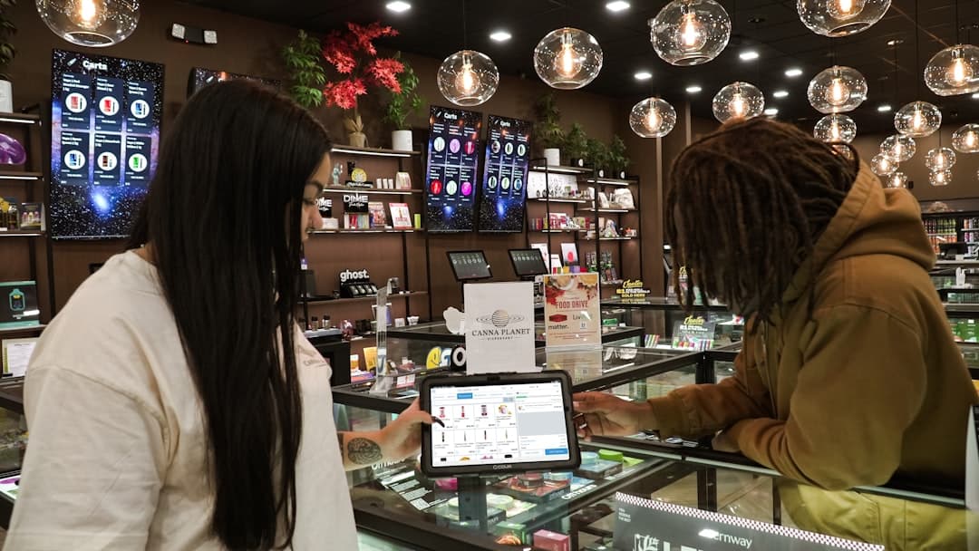 Two people using tablet in cannabis shop