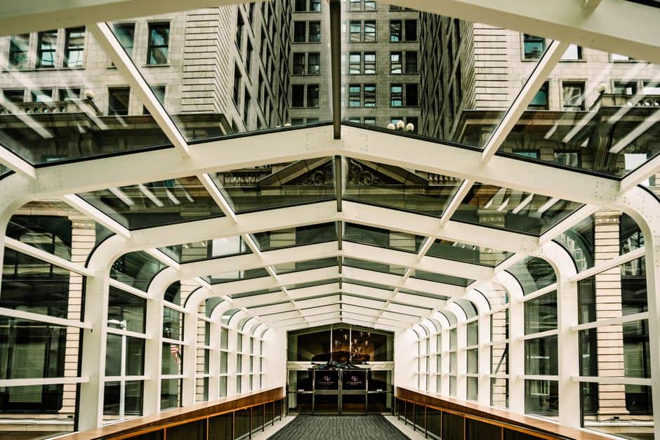 enclosed glass bridge with city buildings
