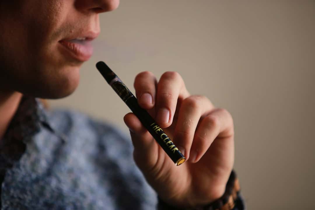 Person holding and using a vape pen