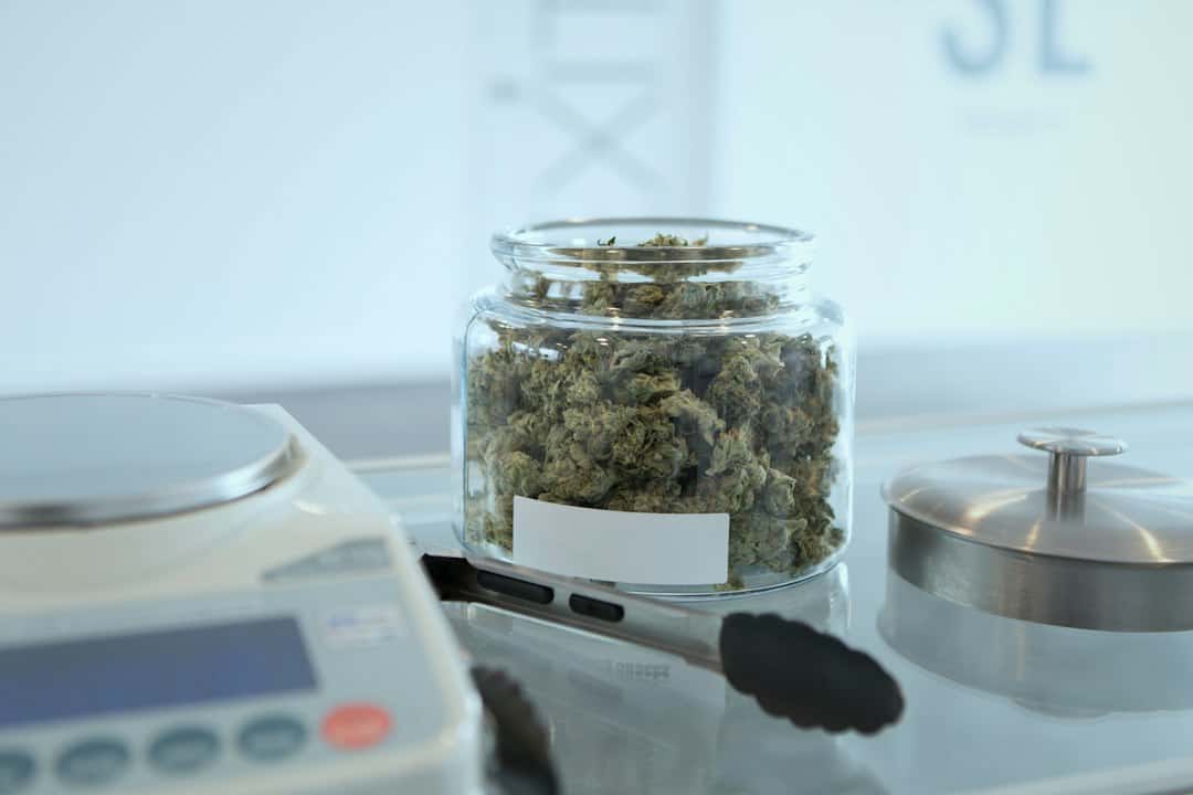 Glass jar of cannabis beside digital scale