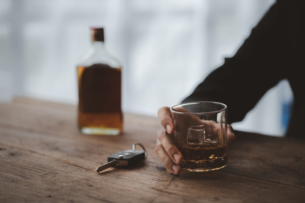Man holding a glass of brandy, he is drinking brandy in a bar.