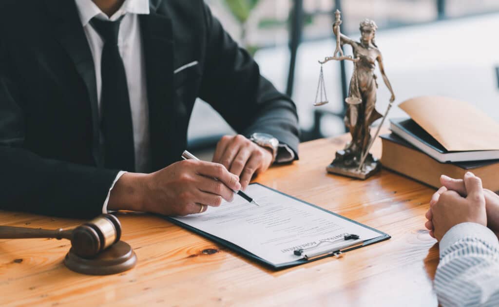 Lawyer reviewing documents with client in office setting.