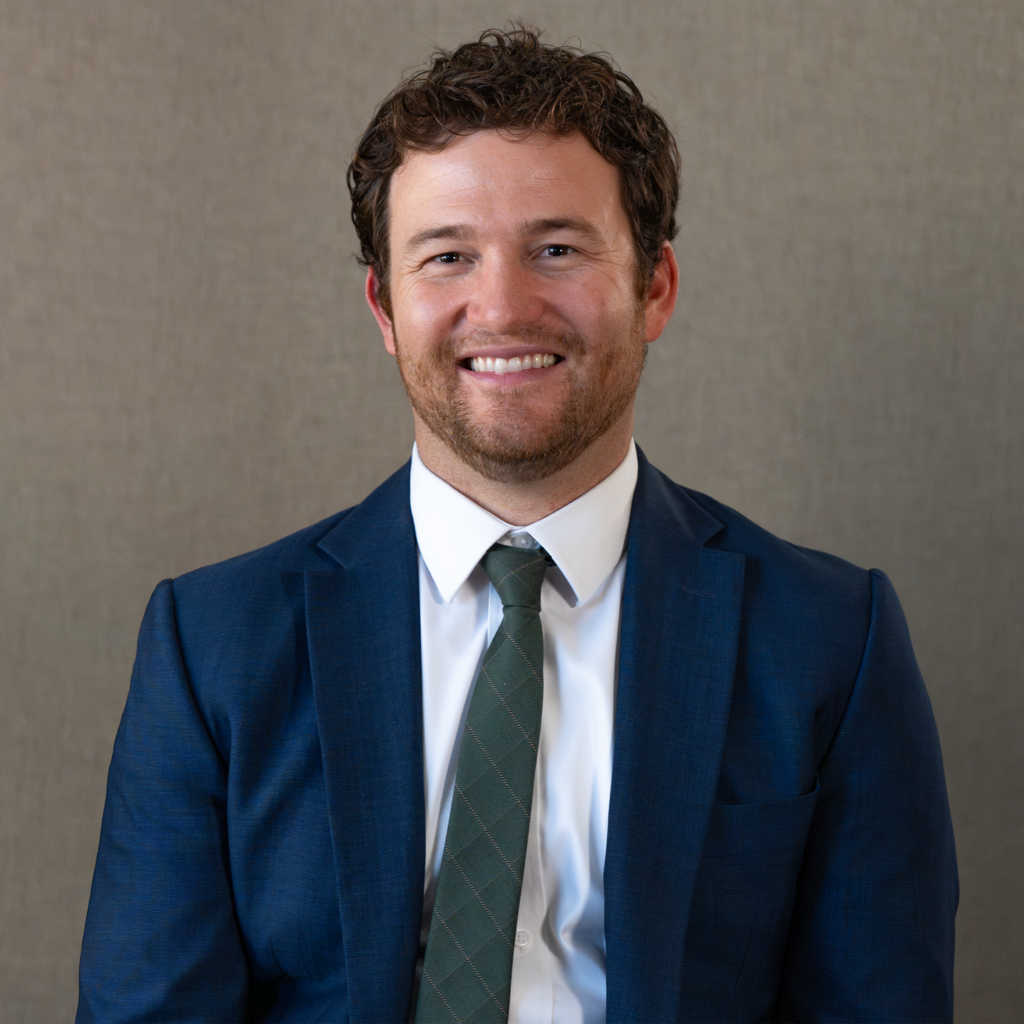 Professional lawyer in blue suit smiling for legal consultation in Arizona.