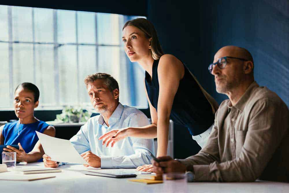 Executive team reviewing documents while considering a critical business decision.