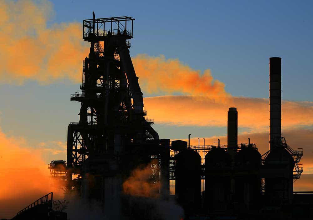 Industrial facility silhouetted at sunset, representing high-risk operating environments and commercial consequence.
