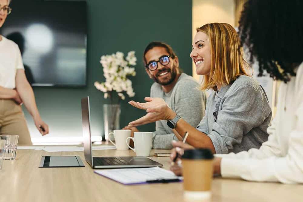 Leadership team engaged in a collaborative decision conversation around a table.