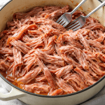 Juicy pulled pork with cranberry sauce in a pot, perfect for low-carb diets.