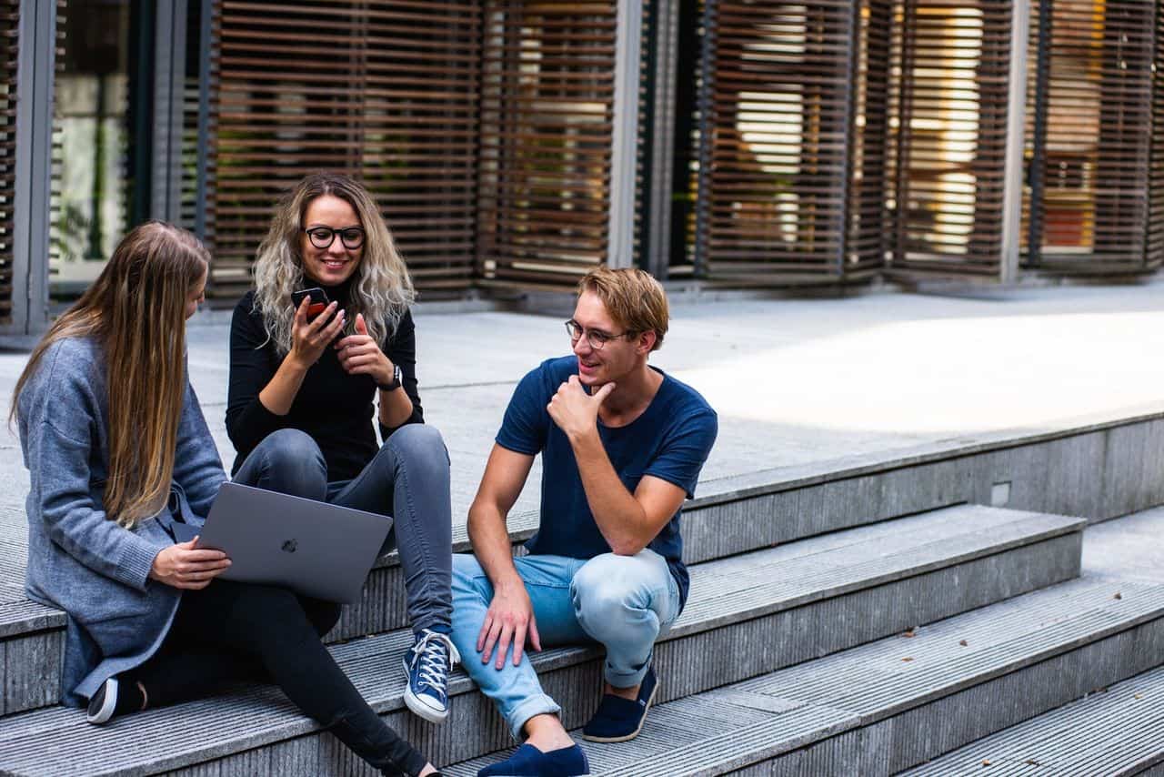 Image of students sitting on the steps of a university