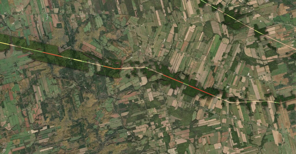 Dark green polygons indicate densely forested areas, with colour indexed markers identifying risk level to power lines.