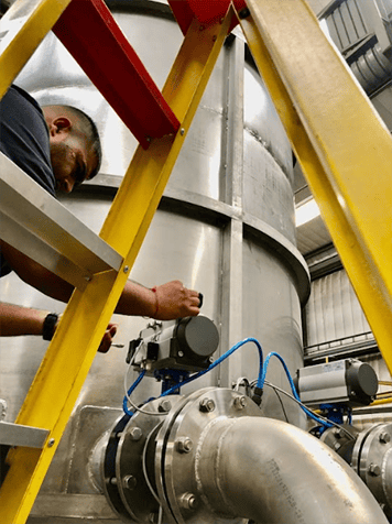 An EMVAfrica technician working on a butterfly valve to ensure the flow is regulated of abrasive slurries and to control the discharge of tailing.
