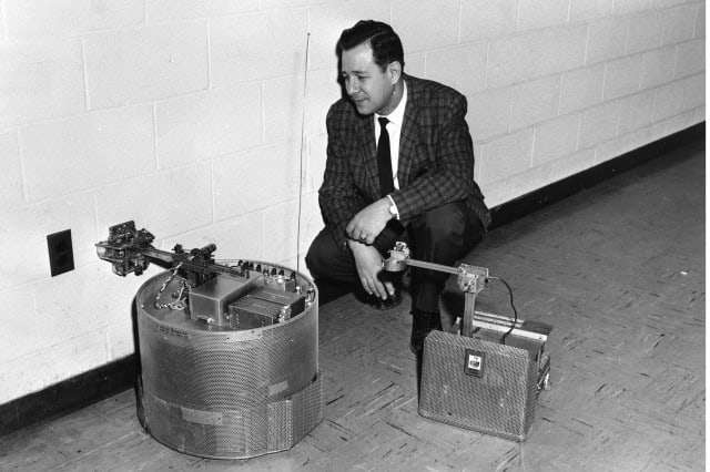 - Vintage black and white photo of a man in a suit working with early radio technology, demonstrating early communication devices.