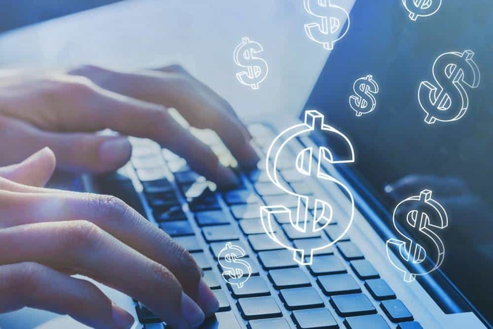 Dollar sign icons over laptop keyboard representing online financial transactions and digital money management in a modern tech environment.