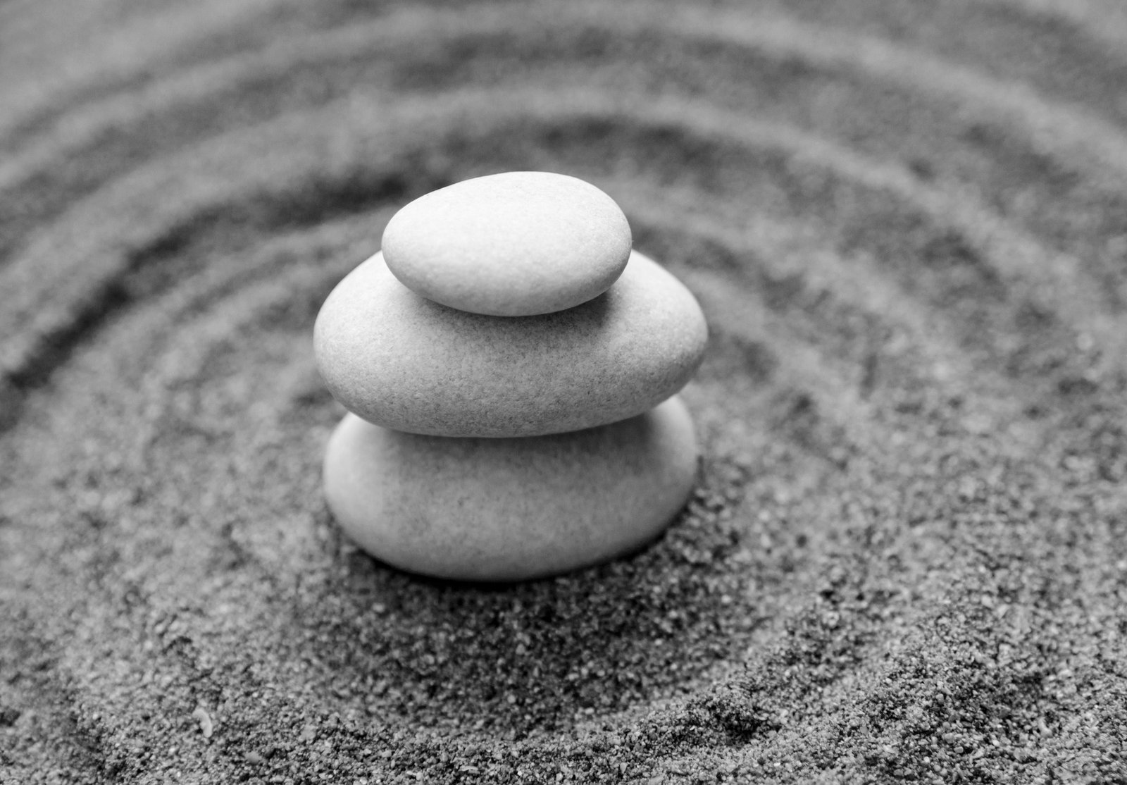 3 Stones stacked on sand