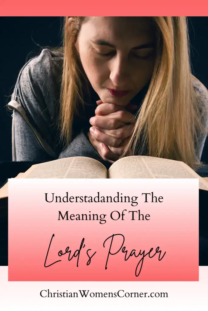 A woman with her hands clasped, praying over a Bible A woman with her hands clasped, praying over a Bible