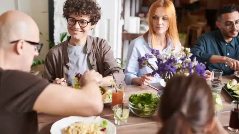 A group of people eating together, symbolizing practicing hospitality