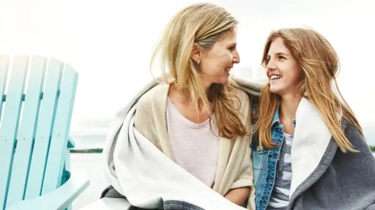 An older christian woman looking at a younger girl and they are both smiling symbolizing "You are enough"