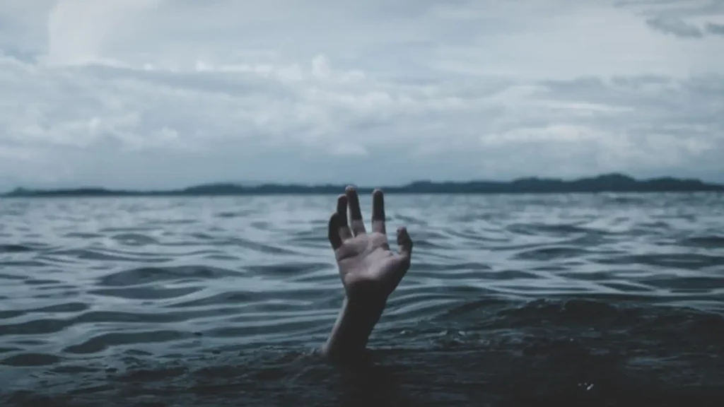 A hand raised up out of the surface of the water symbolizing mental illness