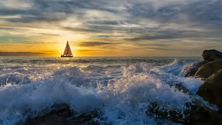 A sailboat drifting into the distant sunset symbolizing coming back to God