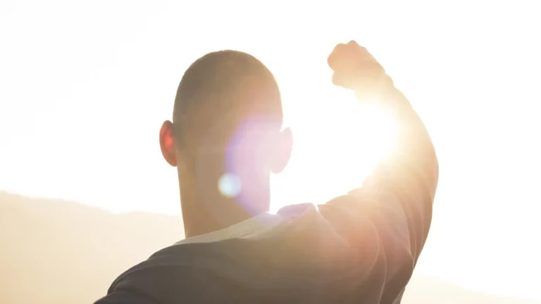 A man with his fist raised towards the sun symbolizing Nehemiah