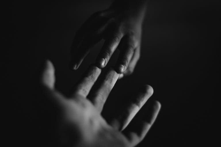 A touching monochrome image of two hands reaching towards each other, symbolizing connection after facing child sexual abuse