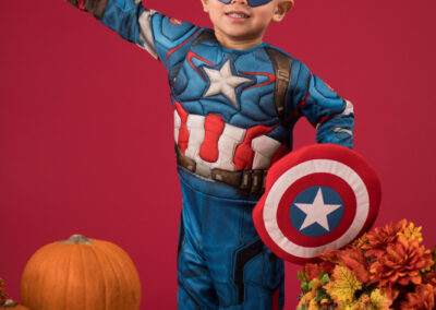 A young boy in a captain america costume posing for a photo.