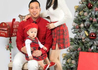 A family posing in front of a christmas tree.
