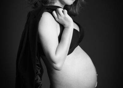A pregnant woman posing for a black and white photo.