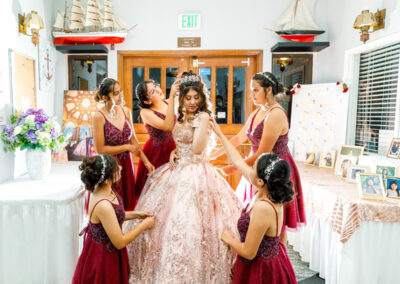 A group of bridesmaids helping each other put on their dresses.