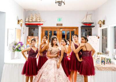 A group of bridesmaids posing in front of a chandelier.