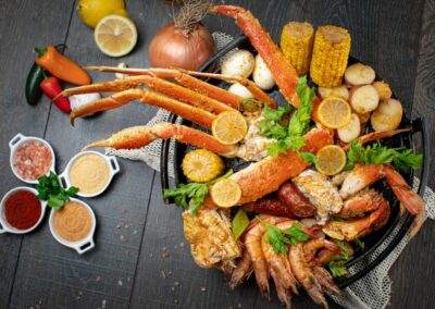 Crabs, shrimp, corn, and other seafood on a wooden table.