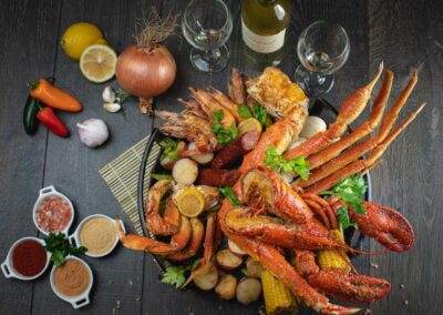 A plate full of seafood and vegetables on a wooden table.