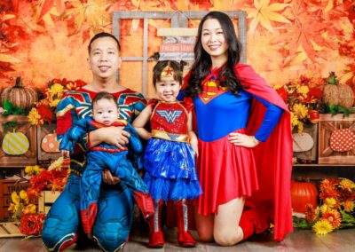 A family posing for a photo in superman costumes.