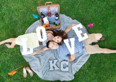 CineCrown engagement session A couple laying on a blanket with the word love written on it.