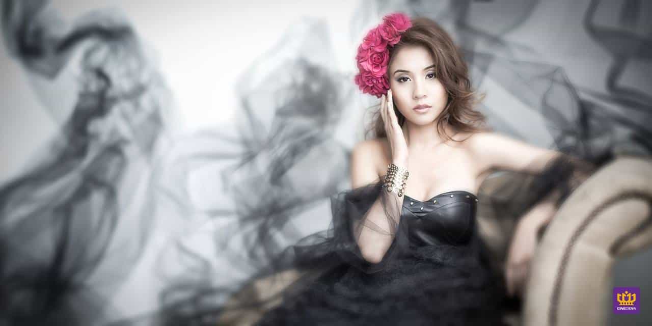 CineCrown glamour photography A woman in a black dress with a flower on her head.