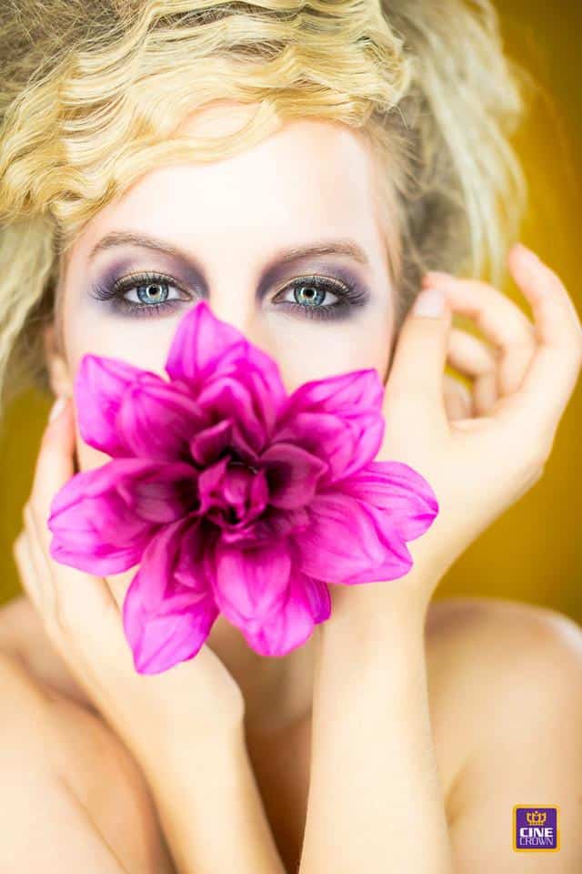 CineCrown glamour photography A woman with a pink flower in her mouth.
