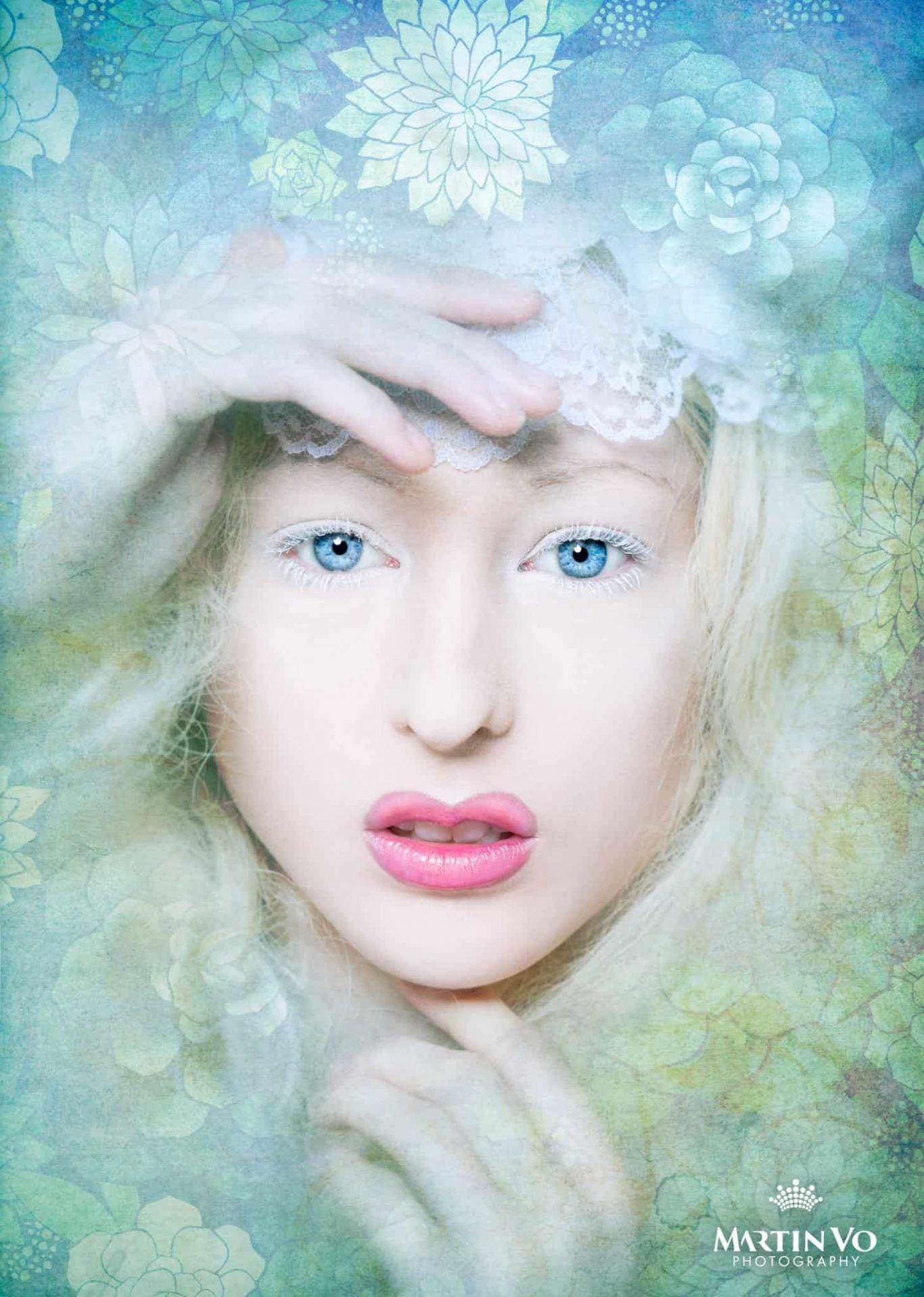 CineCrown glamour photography A woman with blue eyes and flowers on her face.