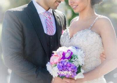 CineCrown Photography A bride and groom holding a bouquet of flowers.