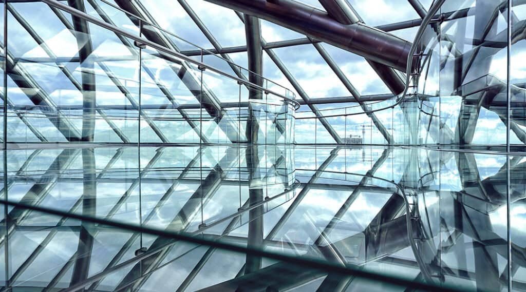 A sleek, contemporary commercial building with extensive glass walls and ceilings, showcasing modern architecture and design elements.