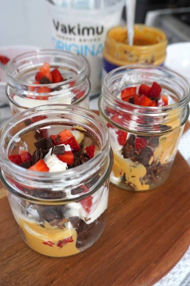 Desayuno saludable para llevar preparado en frasco de vidrio con ingredientes altos en proteína.