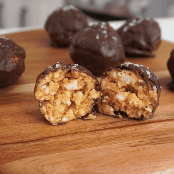 Bolitas crujientes bañadas en chocolate sobre un plato blanco.