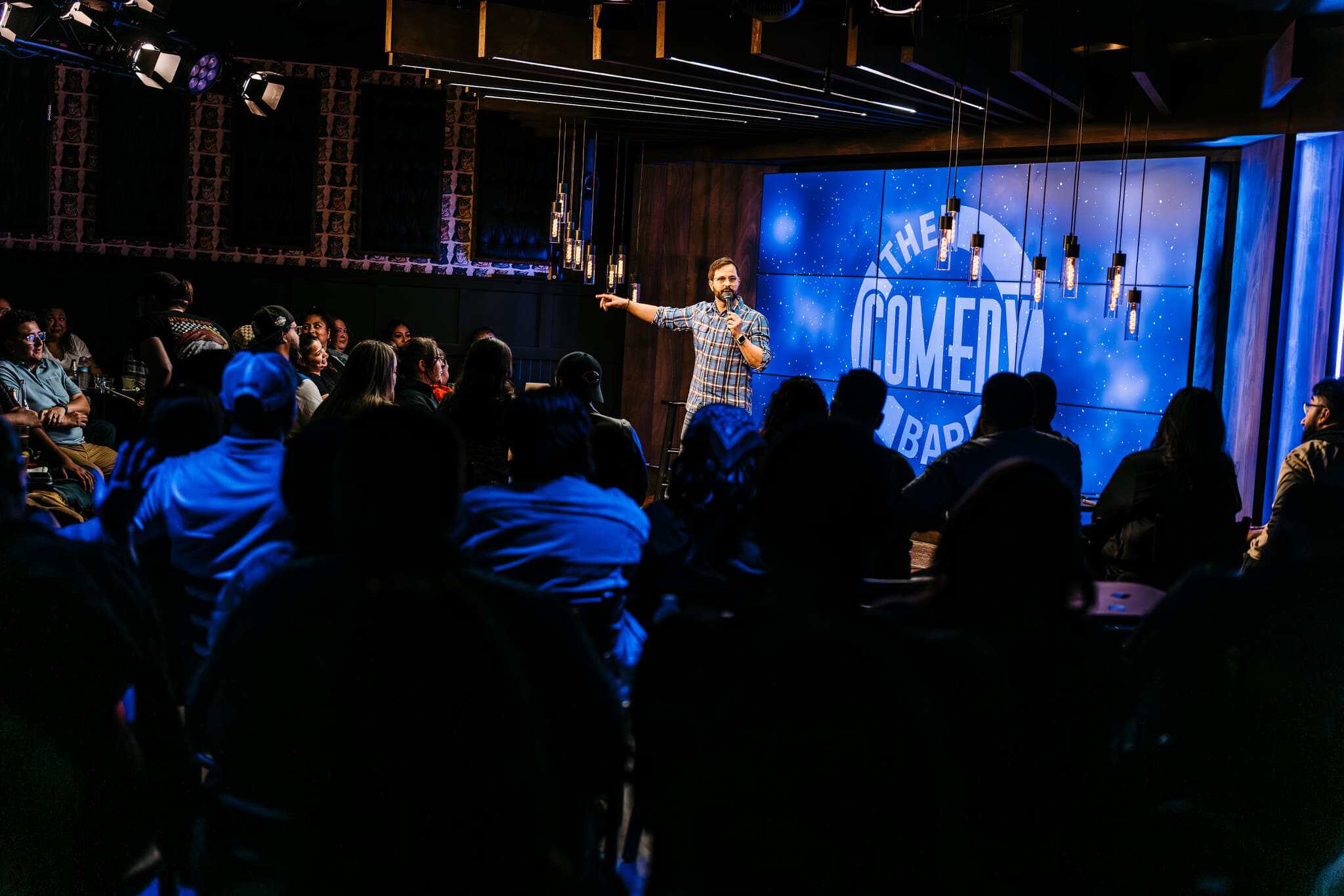 Comedian performing on stage at The Comedy Bar in front of a live audience