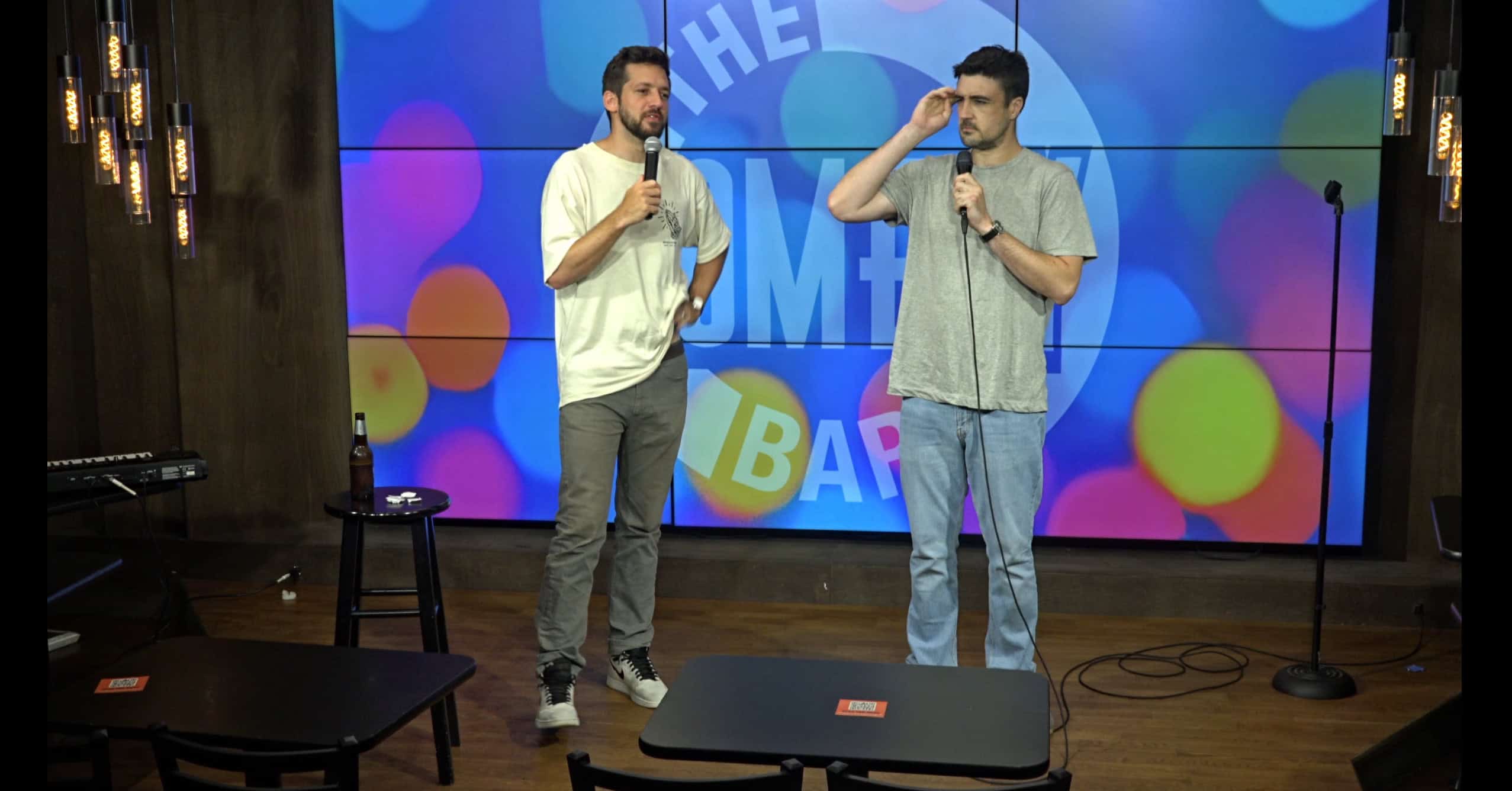 Two comedians with mics on stage at Crowd Work Wednesday at Comedy Bar