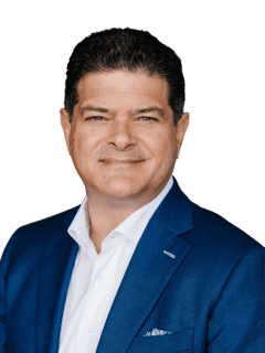 Professional man in a blue suit smiling, representing connection and trust.