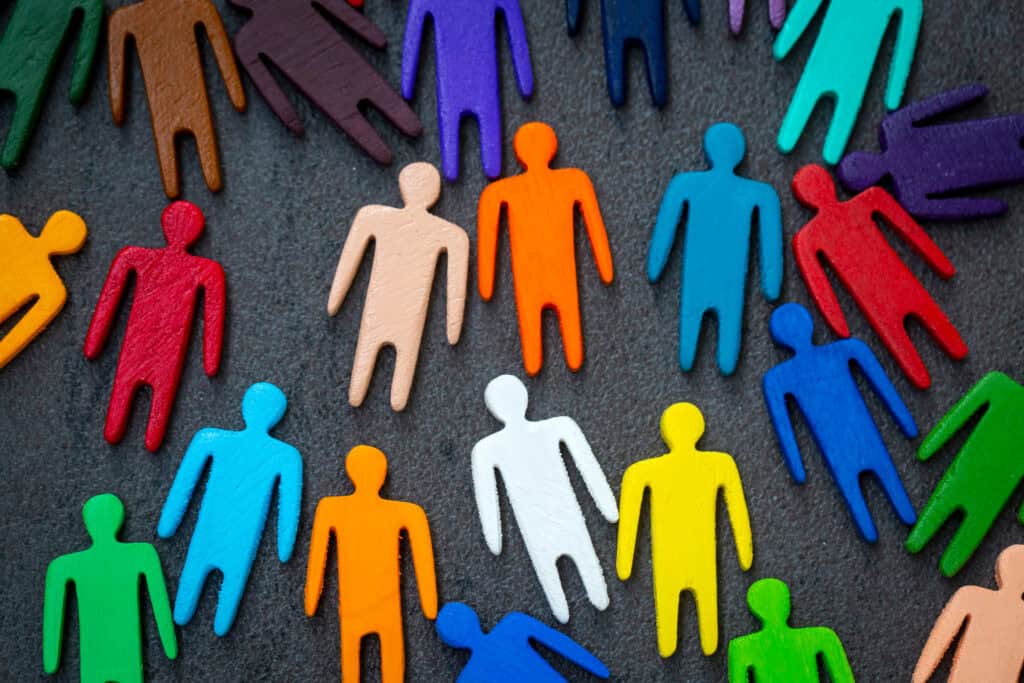 Equality and diversity concept. Multi-colored wooden figurines on a blackboard.