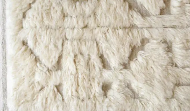 Luxurious cream shearling rug with plush texture for cozy home decor and high-quality flooring solutions.